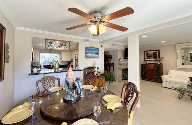 dining area with light wood-type flooring, ceiling fan, and ornamental molding