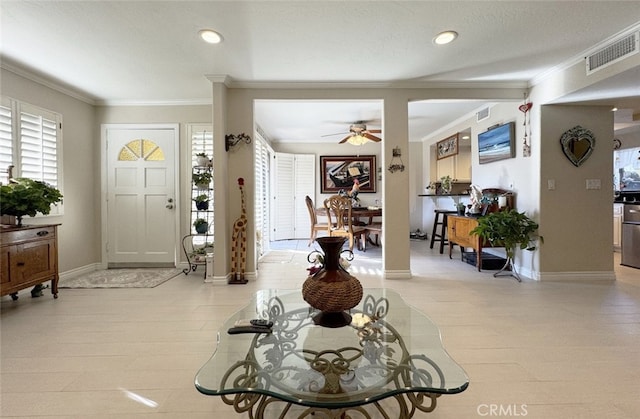 entrance foyer with ceiling fan and crown molding