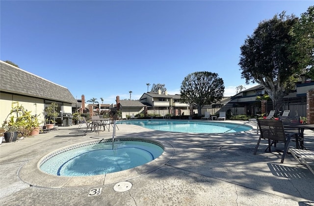 view of swimming pool featuring a patio area and a hot tub