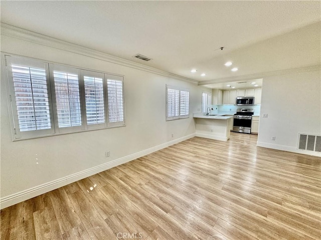 unfurnished living room featuring ornamental molding, light hardwood / wood-style flooring, and sink