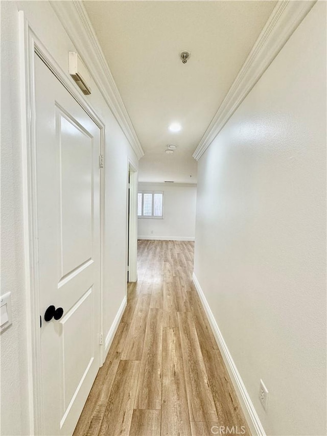 corridor with crown molding and light wood-type flooring