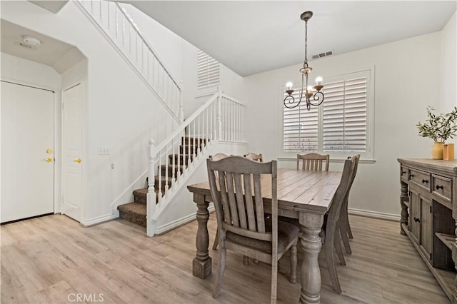 dining area with a notable chandelier and light wood-type flooring