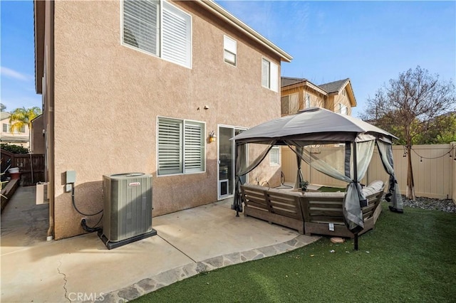 rear view of house featuring a patio area, central air condition unit, a gazebo, a lawn, and an outdoor living space