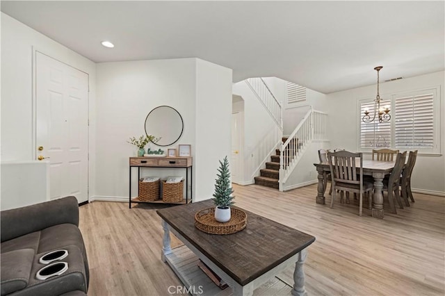 living room with a notable chandelier and light hardwood / wood-style flooring