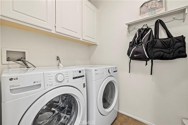 laundry room with cabinets, washing machine and dryer, and light tile patterned floors