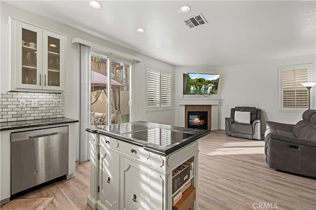 kitchen with white cabinetry, tasteful backsplash, light hardwood / wood-style floors, and dishwasher