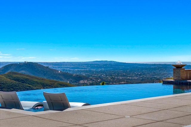 view of swimming pool with a water and mountain view