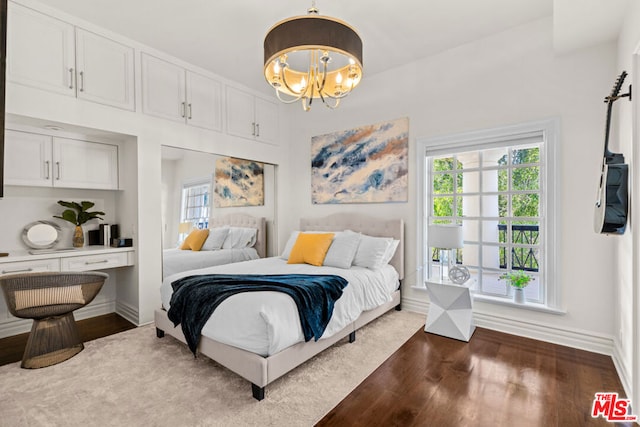 bedroom featuring a chandelier, dark hardwood / wood-style floors, and multiple windows