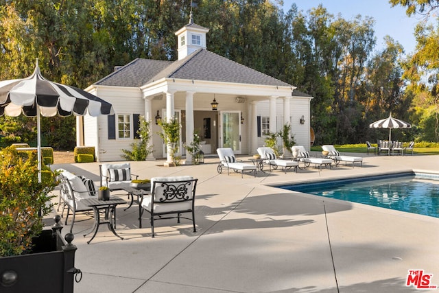 view of swimming pool with a patio and an outdoor structure