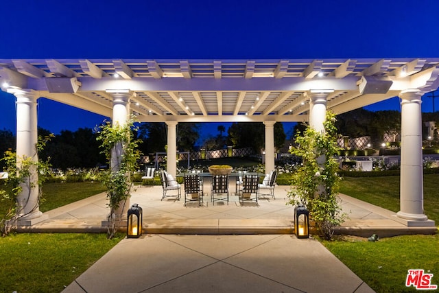 patio at twilight featuring a pergola and a yard