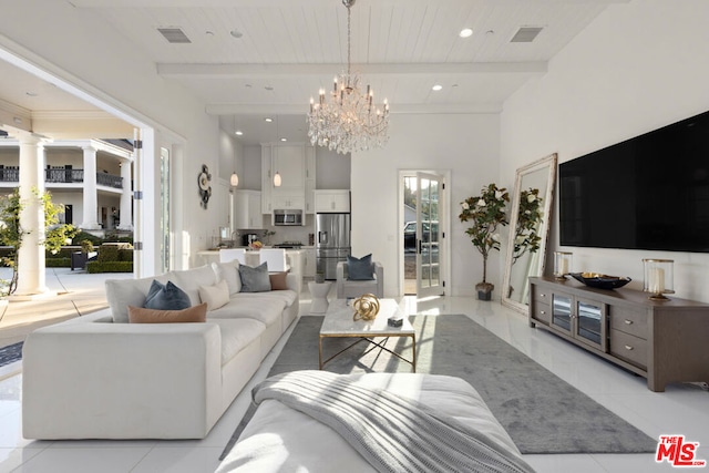 living room featuring beamed ceiling, a high ceiling, a chandelier, and ornate columns