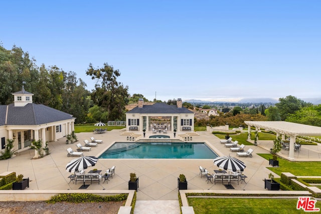 view of swimming pool featuring an outbuilding, a pergola, and a patio