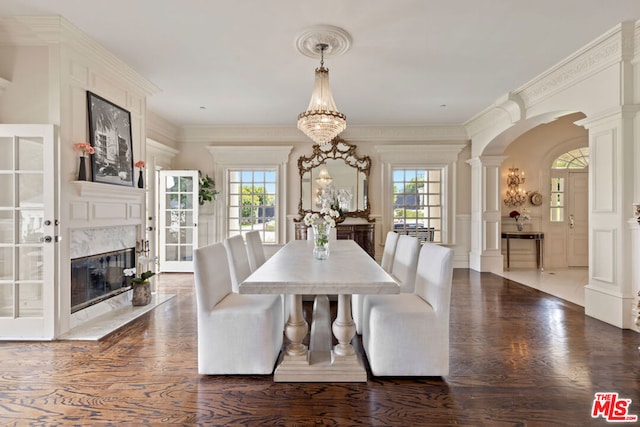 dining room featuring a high end fireplace, ornamental molding, and ornate columns