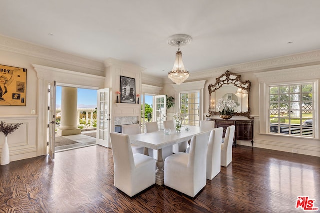 dining area with dark wood-type flooring, crown molding, and a chandelier