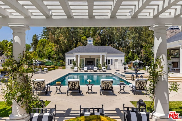 view of pool featuring a pergola, an outbuilding, and a patio