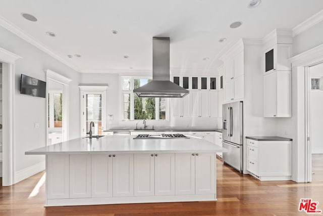 kitchen featuring white cabinetry, appliances with stainless steel finishes, island range hood, and a kitchen island with sink