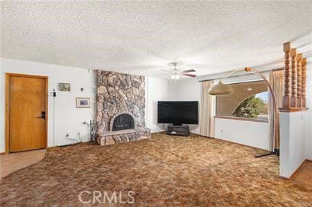 unfurnished living room featuring ceiling fan, a textured ceiling, carpet, and a fireplace