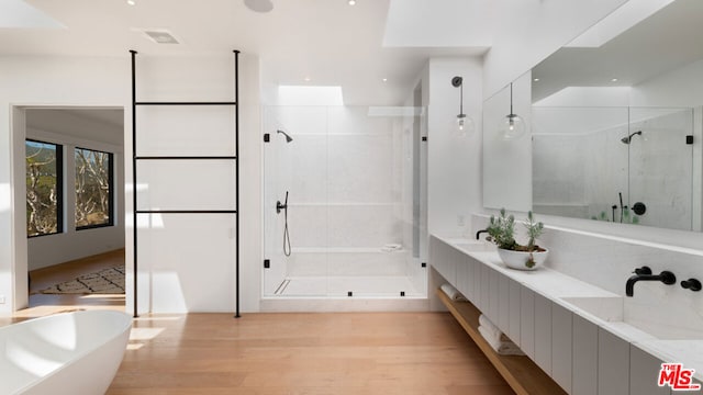 bathroom featuring independent shower and bath, wood-type flooring, and vanity