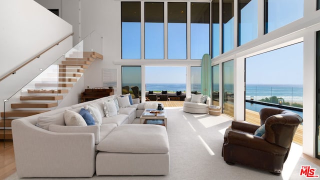 living room featuring a water view and a towering ceiling