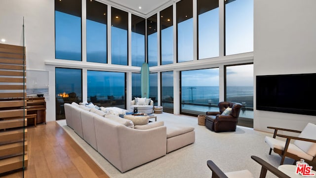 living room featuring light wood-type flooring and a high ceiling