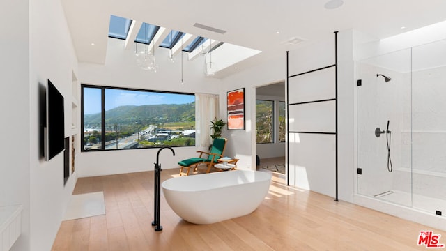 bathroom featuring independent shower and bath and hardwood / wood-style floors