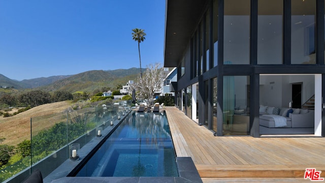 view of swimming pool featuring a mountain view and an in ground hot tub