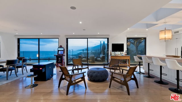 dining space featuring floor to ceiling windows, a water view, and hardwood / wood-style flooring