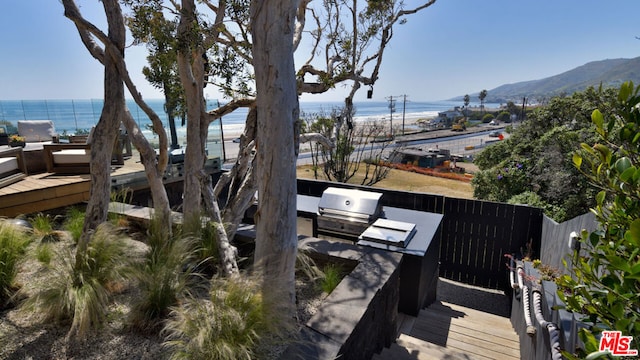 exterior space featuring a grill, a water and mountain view, and area for grilling