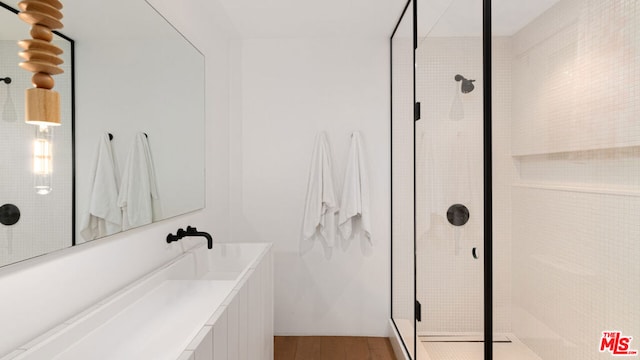 bathroom featuring a shower with shower door and hardwood / wood-style flooring