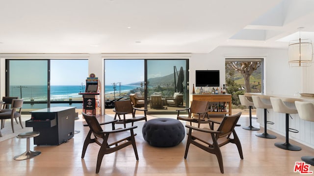 interior space featuring floor to ceiling windows, light hardwood / wood-style floors, a notable chandelier, and a water view