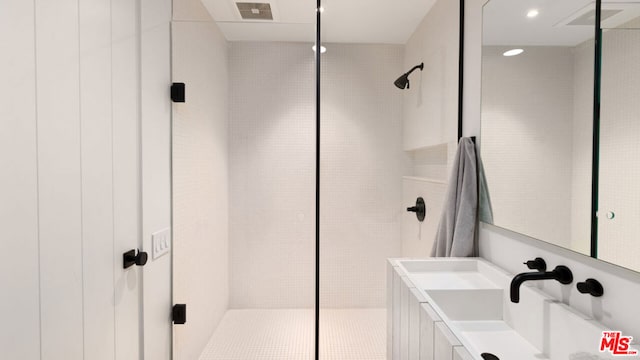 bathroom featuring walk in shower and vanity