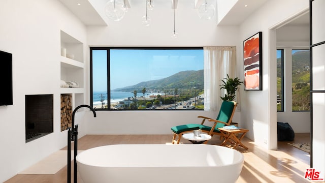 bathroom featuring built in shelves, a bathtub, and a mountain view