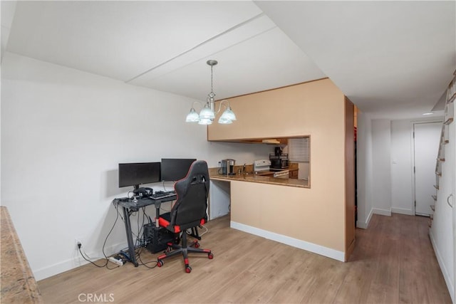 home office with light hardwood / wood-style floors and a chandelier