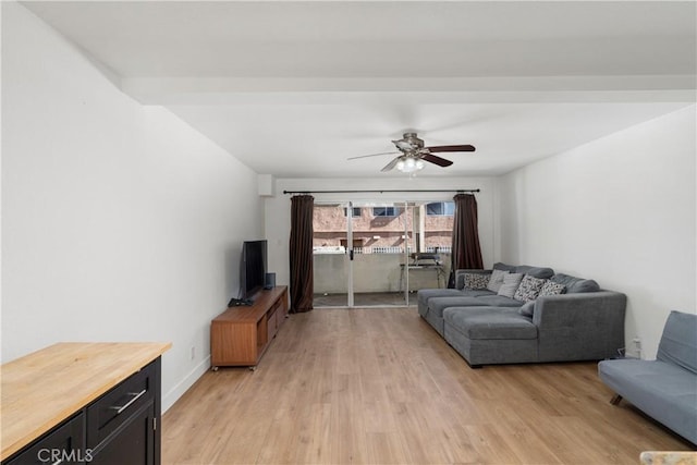 living room with light wood-type flooring, ceiling fan, and beamed ceiling