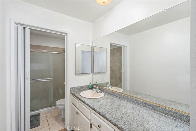 bathroom featuring a shower with door, toilet, tile patterned floors, and vanity