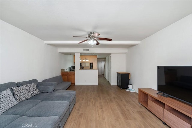 living room with light hardwood / wood-style floors, beam ceiling, and ceiling fan