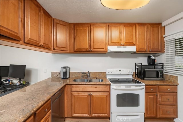 kitchen with light stone counters, sink, and appliances with stainless steel finishes