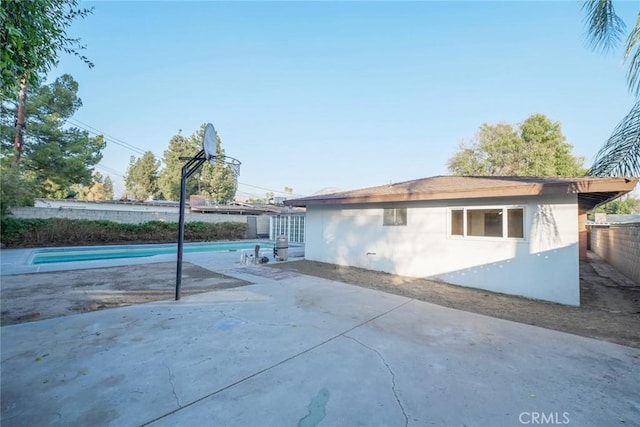 view of side of property featuring a fenced in pool and a patio