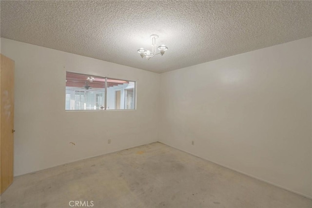 carpeted empty room with a notable chandelier and a textured ceiling