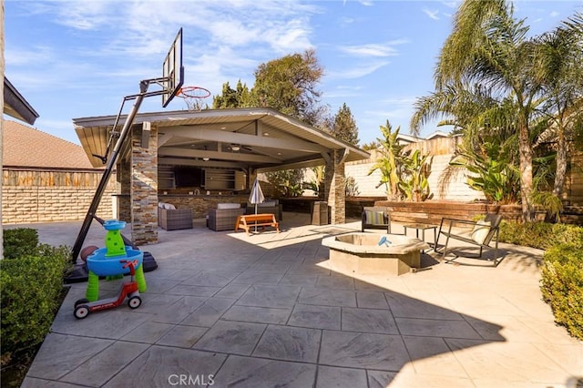 view of patio with ceiling fan, a gazebo, a fire pit, and area for grilling