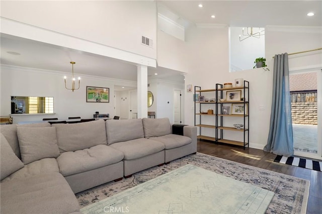 living room with hardwood / wood-style floors, ornamental molding, and a notable chandelier