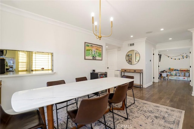 dining room with dark hardwood / wood-style floors, ornamental molding, and an inviting chandelier