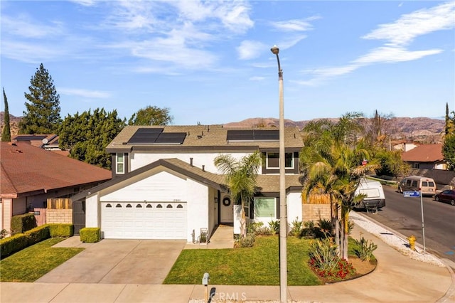 view of front of home with a garage, solar panels, and a front yard