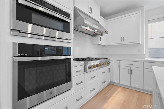 kitchen with white cabinetry, stainless steel appliances, and light wood-type flooring