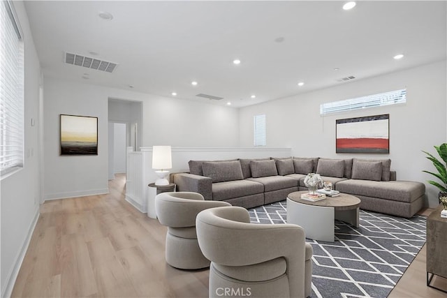 living room with plenty of natural light and light hardwood / wood-style flooring