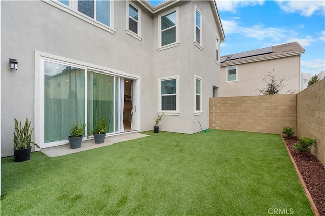 rear view of property featuring a lawn