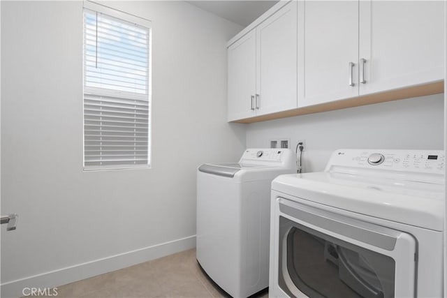 washroom featuring cabinets, washing machine and clothes dryer, and light tile patterned floors