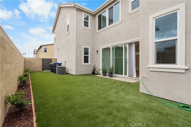 back of property with central air condition unit and a lawn