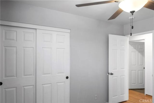 unfurnished bedroom with ceiling fan, hardwood / wood-style floors, and a closet