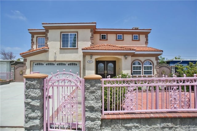 mediterranean / spanish-style house featuring a garage and french doors